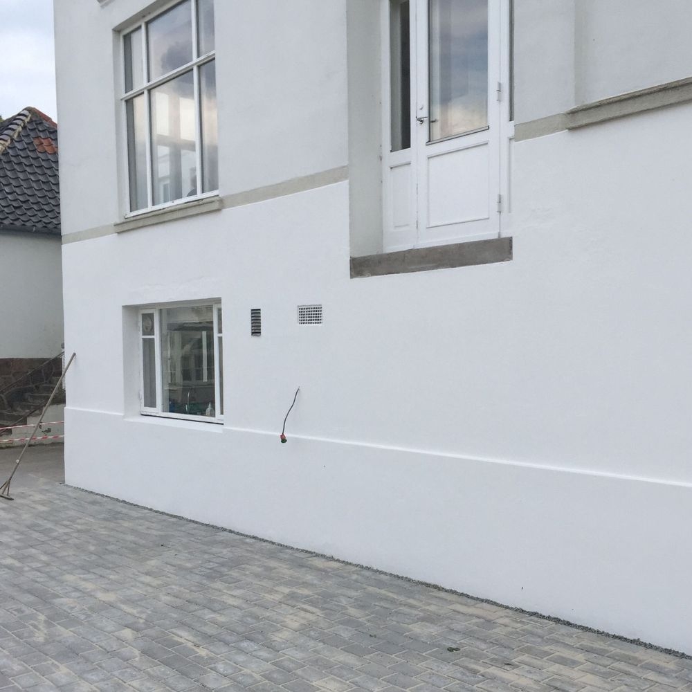 Ny pudset og malet hvid facade på etageejendom